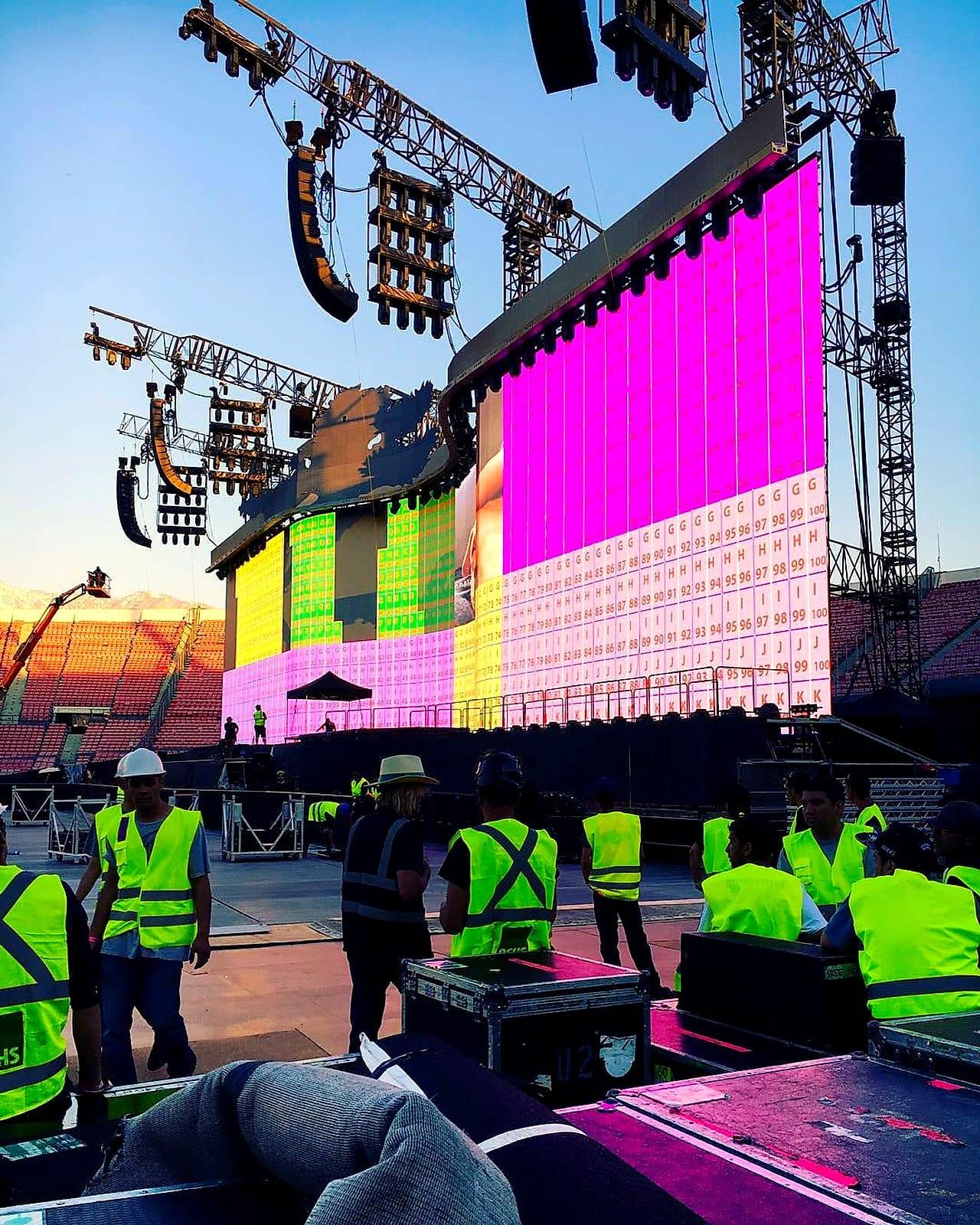 Stage hands de Kpital con chalecos reflectantes montando un escenario con pantallas LED